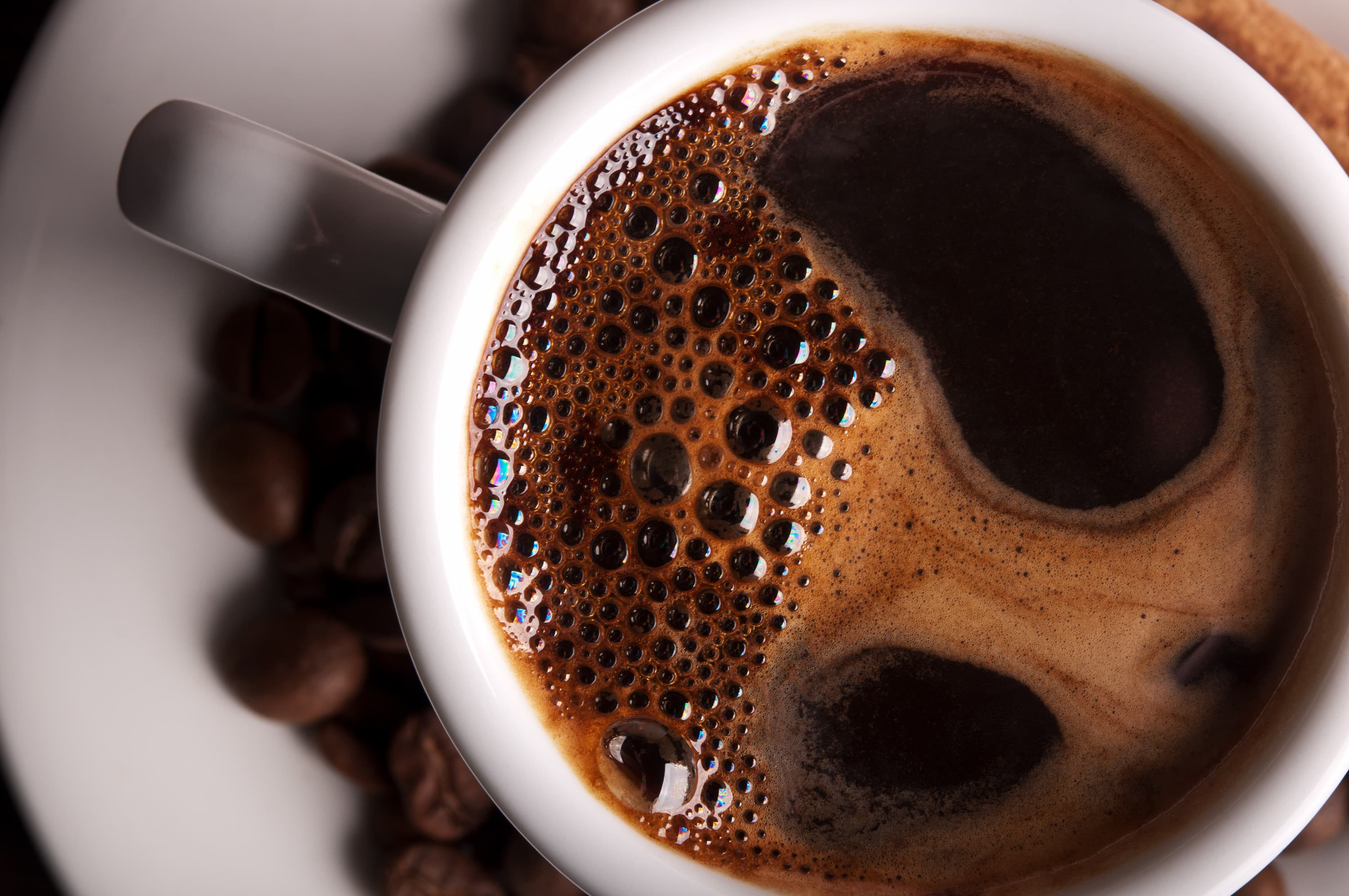Nahaufnahme einer Tasse mit frisch gebrühtem schwarzem Kaffee und dichter Crema.