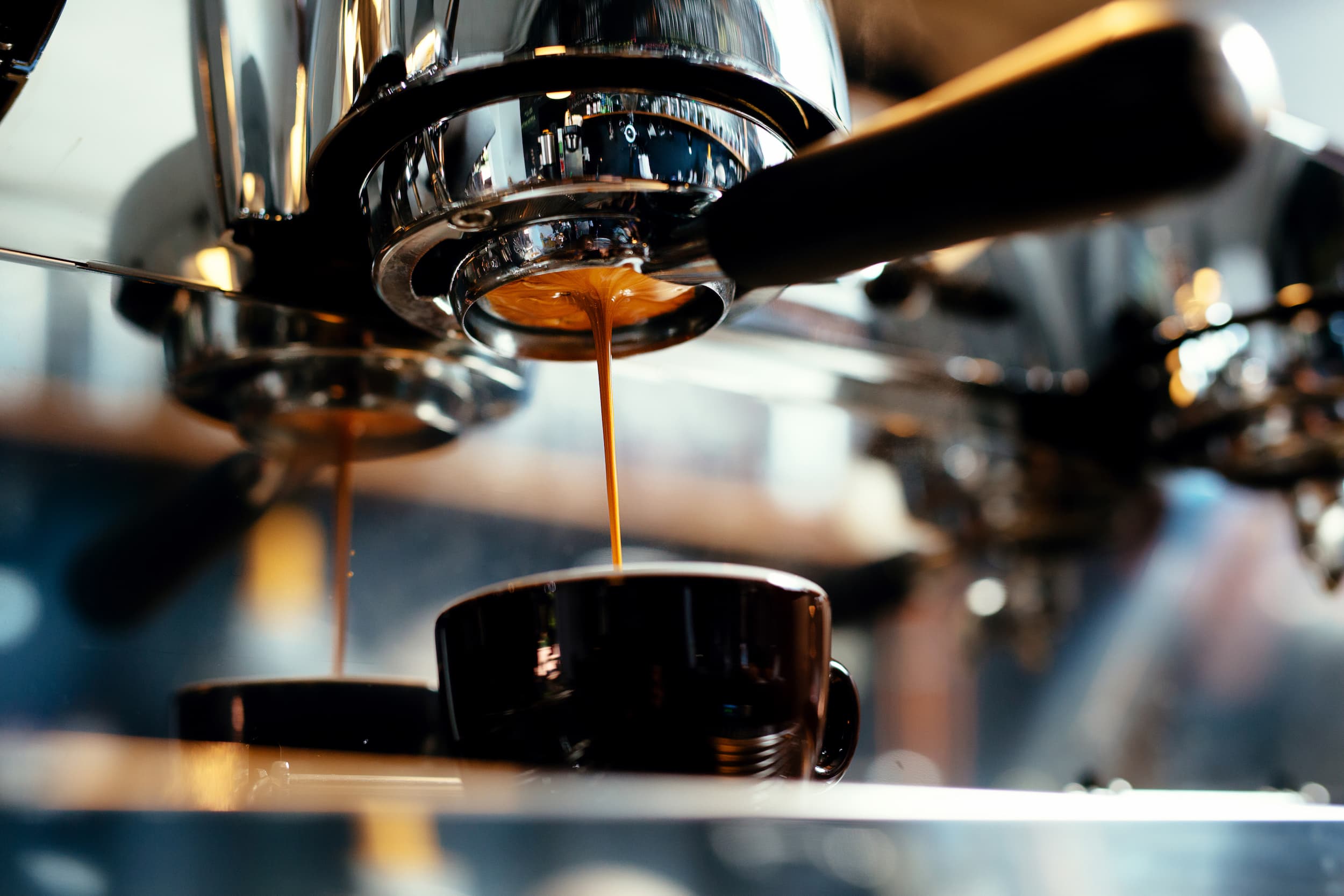 Nahaufnahme einer Siebträgermaschine, Espresso läuft in eine Tasse.
