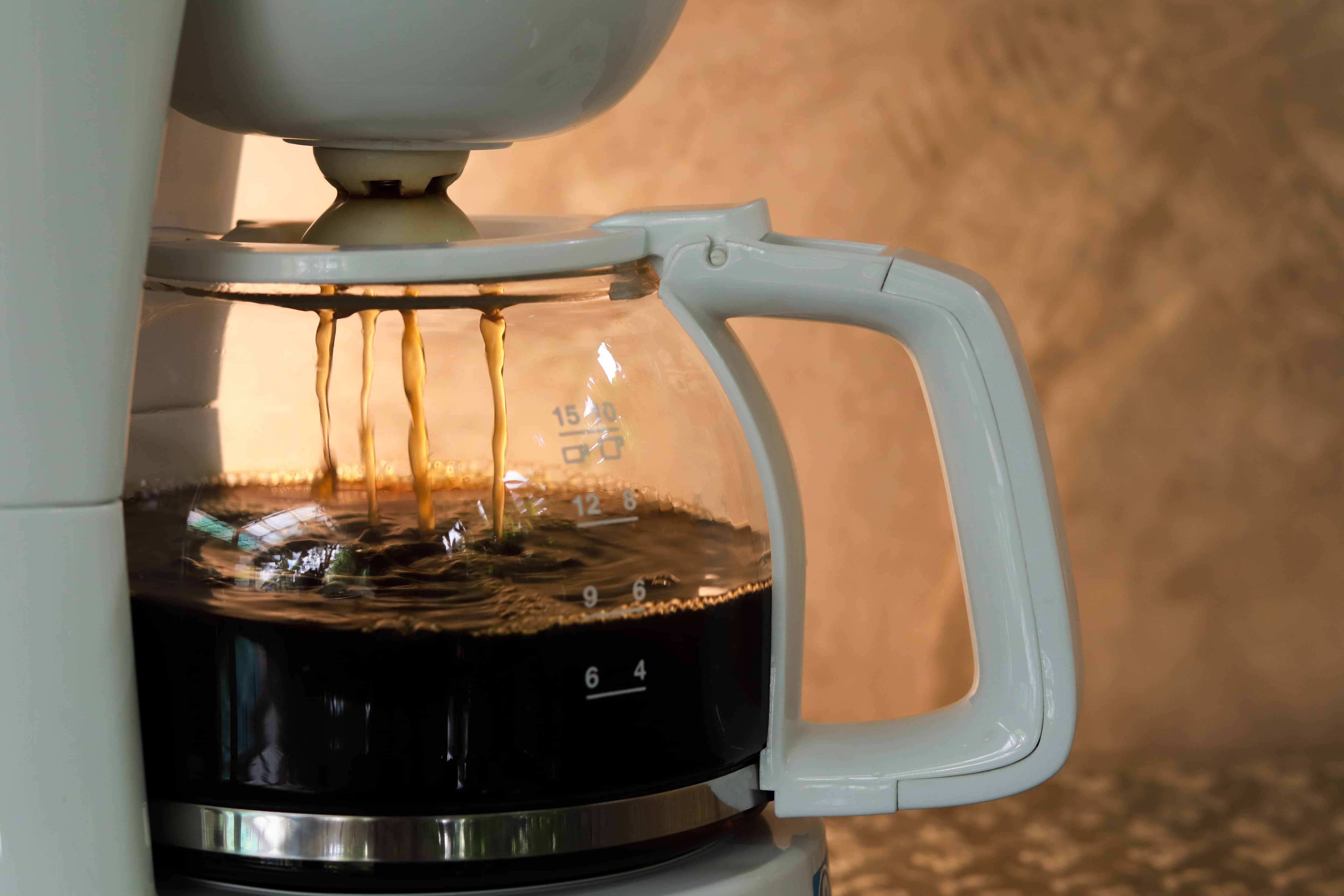 Kaffeemaschine brüht frischen Kaffee direkt in eine Glaskanne mit Skala.
