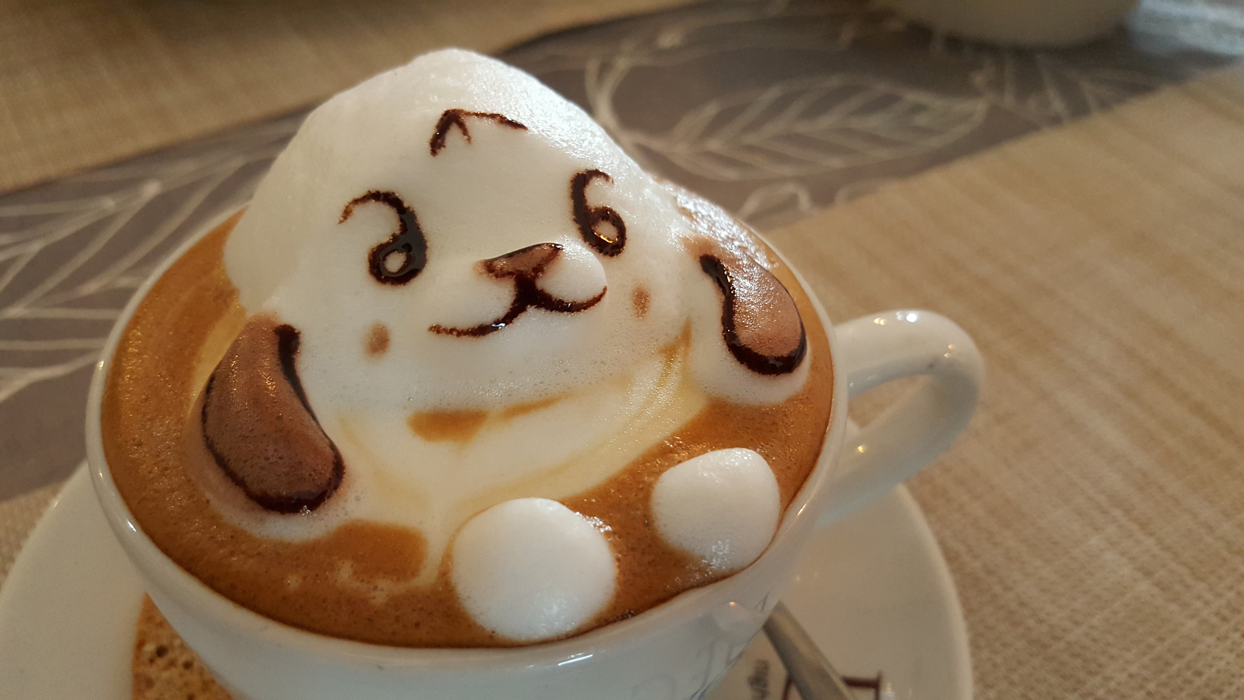 Kaffeetasse mit 3D-Latte-Art in Form eines Hundegesichts aus Milchschaum und Schokolade.